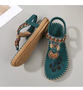 Detail van Boheemse sandalen met strass-hartjes en kleurrijke kralenversieringen
