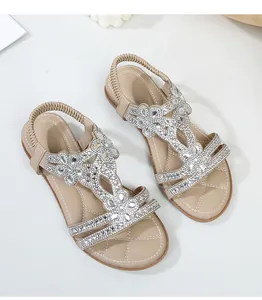 Dettagli dei sandali beige con strass, motivi geometrici e solette trapuntate cucite