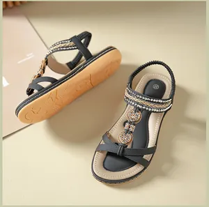 Detail of black flat sandals with heart rhinestones and woven elastic back strap