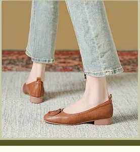 Detailweergave van bruine matte leren platte schoenen met ronde gesp en zachte zool dames