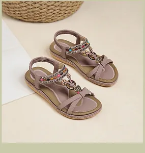 Détails de sandales bohèmes avec perles colorées et ornements en métal en forme de cœur