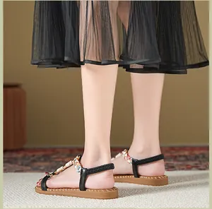Detailansicht von flachen Sandalen mit Strasssteinen und elastischem Fersenriemen