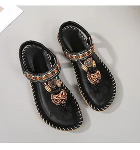 Detail van bohemian sandalen met etnische kralen, vlinders en kleurrijk borduursel