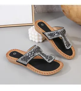 Detalle de sandalias planas bohemias con brillantes pedrería plateada y cristales