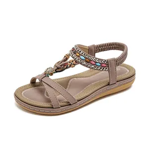 Sandales plates bohèmes avec strass et perles mauves sur fond blanc pur