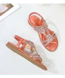 Vista dettagliata dall'alto di sandali arancioni con strass e motivi floreali boho