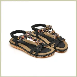 Detail von Boho-Sandalen mit bunten Perlenstickereien und floralen Metallapplikationen