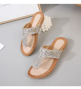 Detalle de sandalias planas bohemias con pedrería brillante y diseño de tira en T