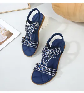 Dettaglio dei sandali bassi boho blu con intricati motivi floreali in strass e perline