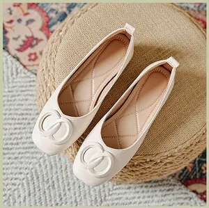 Detail van beige loafers met metalen ringen en gewatteerde binnenzolen voor dames