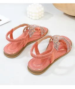 Dettagli dei sandali bassi oro rosa con strass luccicanti e cinturino elastico sul tallone