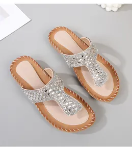 Detalle de sandalias boho con pedrería plateada y bordes con costuras blancas hechas a mano