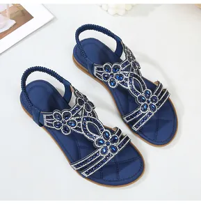 Dettaglio di sandali boho blu con strass scintillanti e ricami di perline decorativi