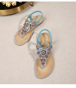 Detail of bohemian sandals with colorful bead patterns and rhinestone edges on the sole