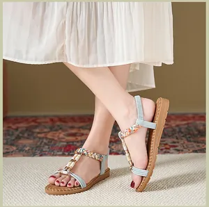 Nahaufnahme von Boho-Sandalen mit bunten Perlen und elastischem Fersenriemen am Fuß