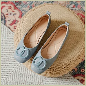 Detailopname van lichtblauwe zachte leren loafers met dubbele ringgespen op een geweven mat