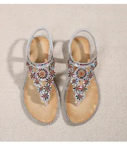 Detail of bohemian wedge sandals featuring colorful rhinestone floral patterns and elastic strap
