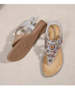 Close-up of bohemian silver sandals with colorful rhinestone floral patterns and non-slip sole