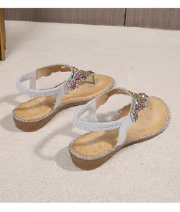 Detail of bohemian flat sandals featuring colorful beads and elastic silver back strap