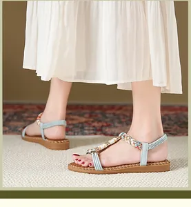 Detail von blauen T-Steg Sandalen mit bunt gewebten Riemen und elastischem Fersenband