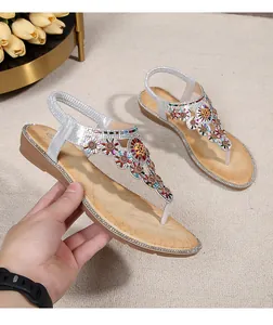 Detail of silver bohemian wedge sandals featuring colorful gemstone floral beads and rhinestones