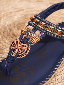 Detailopname van boho-sandalen met kralen vlinder, strassteentjes en bloemen T-band