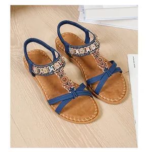 Detail of navy blue bohemian sandals with metal butterfly charms and crystal beadwork