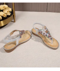 Detail of bohemian wedge sandals with floral rhinestones and glittery elastic strap