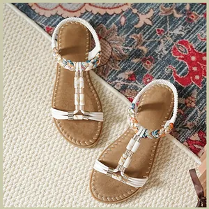 Details flacher Bohemian-Sandalen mit Marmorperlen und bunt geflochtenen Knöchelriemen