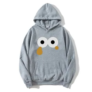 Close-up of light grey hoodie featuring cartoon eye graphic and kangaroo pocket detail