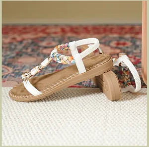 Detail von flachen T-Steg Sandalen mit bunten Webkordeln und weißem elastischem Fersenband