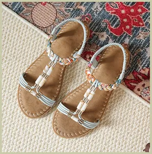 Details flacher Bohemian-Sandalen mit bunten Webebändern und Marmorperlen-Akzenten
