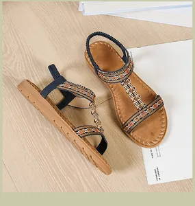 Detalle de sandalias planas bohemias con tiras étnicas y adornos de abalorios