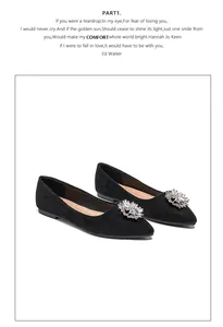 Close-up of black suede pointed flats featuring a large sparkling crystal floral buckle detail
