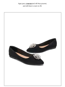 Macro detail of black suede pointed toe flat with sparkling crystal flower buckle