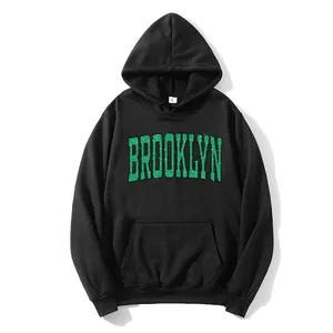 Detail of green Brooklyn print on black hoodie with kangaroo pocket and ribbed cuffs