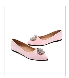 Detailed macro view of pink suede flat shoe featuring sparkling rhinestone flower buckle