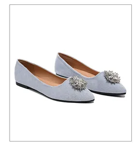 Close-up of light blue suede pointed-toe flat shoe with sparkling crystal buckle detail