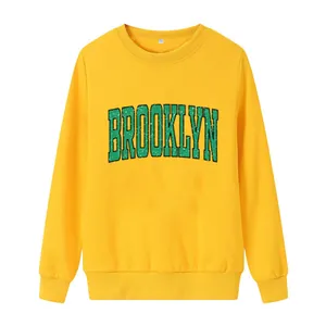 Bright yellow crewneck sweatshirt with vintage green Brooklyn print and ribbed cuffs
