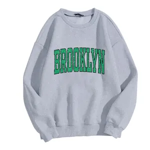 Detail of grey crewneck sweatshirt featuring vintage Brooklyn letter print and ribbed cuffs