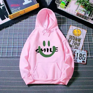 Detailed view of pink hoodie with a green smiley face and smile print lettering