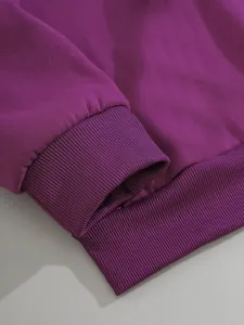 Détail des poignets et de l'ourlet côtelés sur un sweat à capuche violet ample