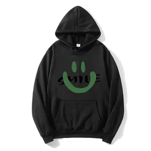 Close-up of black hooded sweatshirt featuring a green smiley face and SMILE text print