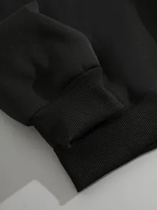 Vue détaillée des poignets et de l'ourlet côtelés de ce sweat à capuche noir