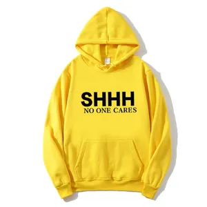 Detail view of bold 'SHHH' slogan print on a bright yellow cotton hoodie with kangaroo pocket
