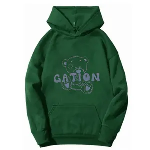Dettaglio felpa con cappuccio verde scuro con scritta GATION, orso e tasca a marsupio
