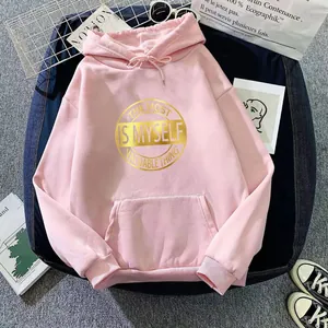 Detail of pink oversized hoodie with golden slogan print and drawstring hood detail