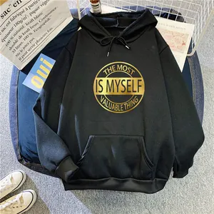 Detail of oversized black hoodie with golden typography print and a kangaroo pocket