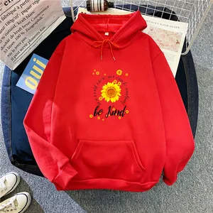Close-up of bright red hoodie with sunflower print and Be Kind motivational text detail