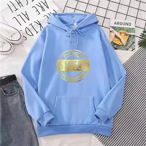 Flat lay of an oversized light blue hoodie with gold circular graphic print and drawstring